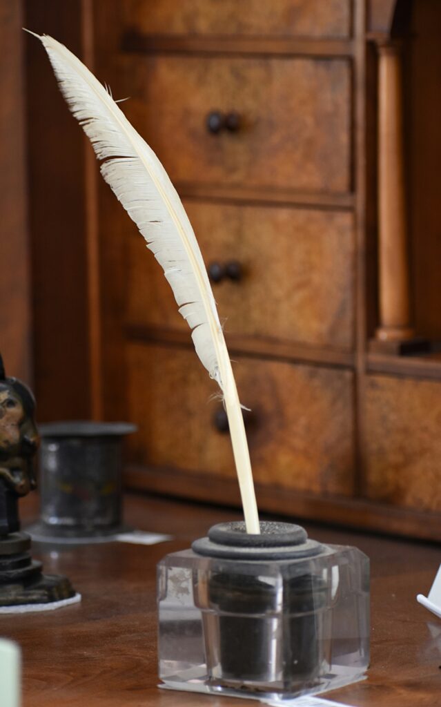 a quill standing in an inkwell