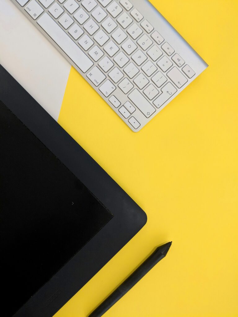 laptop and keyboard on a yellow background